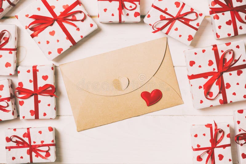 Envelope Mail with Red Heart and gift box over Wooden vintage toned Background. Valentine Day Card, Love or Wedding Greeting