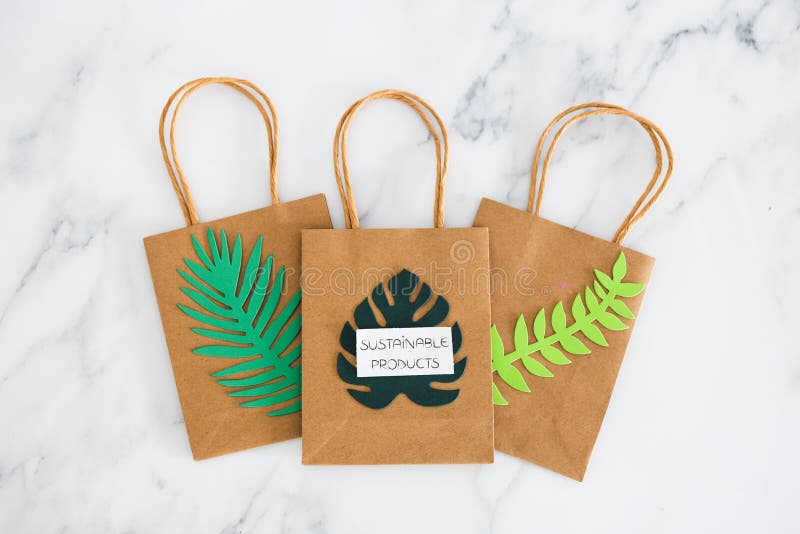 Environmental awareness and consumer behaviour concept, Sustainable Product text on shopping bag with tropical green paper leaves