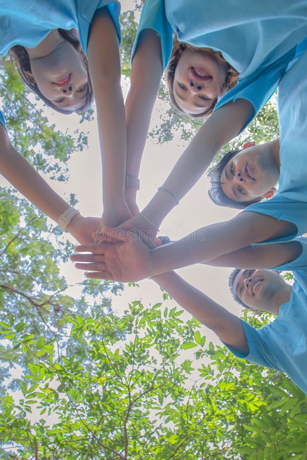 Environmental conservation group of men and women join hands for teamwork stock images