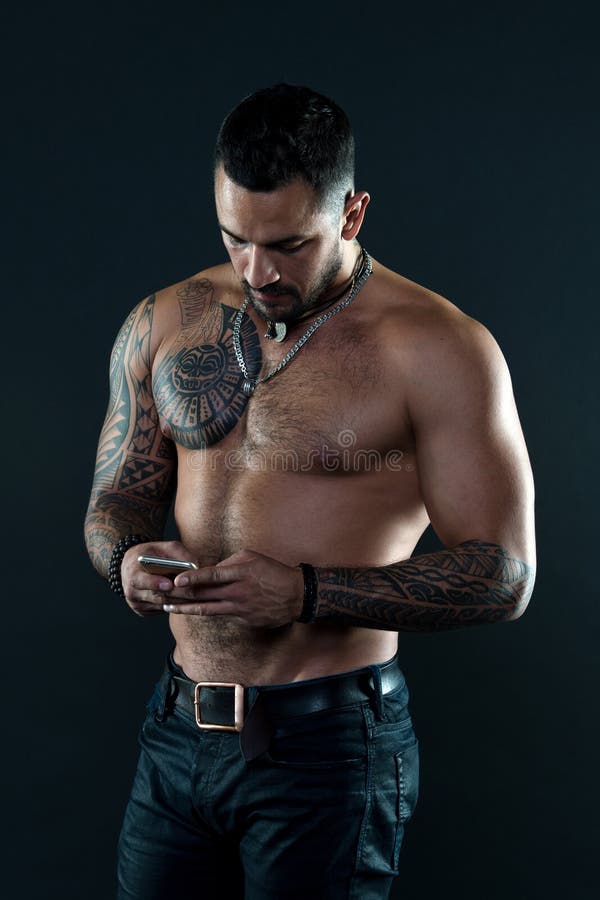 Envoyez le message Homme convenable bel envoyer le smartphone de message Sembler tatoué musculaire d'athlète attrayant messaging photo stock Envoyez le message Homme convenable bel envoyer le smartphone de message Sembler tatoué musculaire d'athlète attrayant messaging photo stock