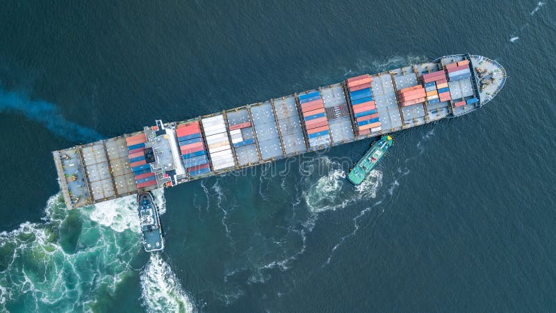 Envío de contenedores de visión aérea y arrastre de remolcador a contenedor de puertos para carga de buques para logística comerci imagenes de archivo