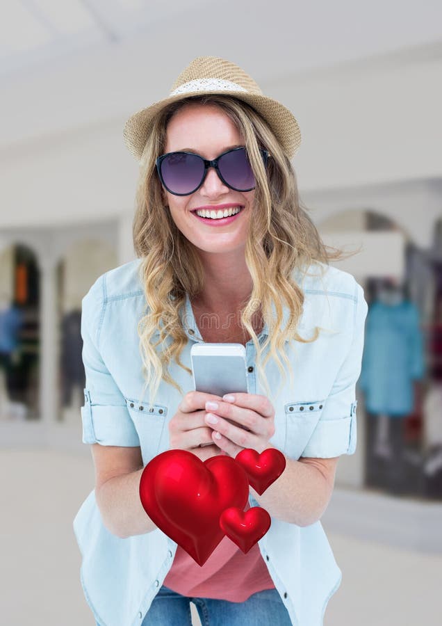 Envío de mensajes de texto feliz de la mujer en el teléfono móvil foto de archivo Envío de mensajes de texto feliz de la mujer en el teléfono móvil foto de archivo