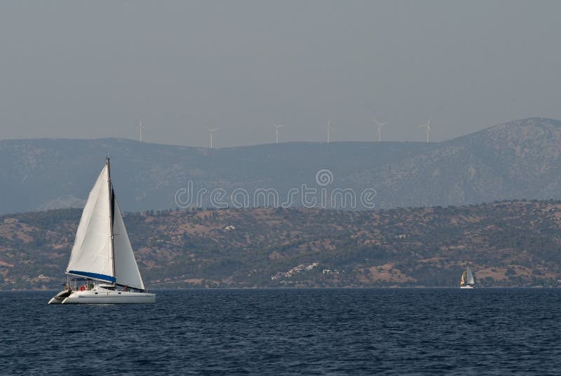 Boats sailing in Greece, in front of wind turbines on the shore. Adventurer adventure stock images, royalty-free photos and pictures