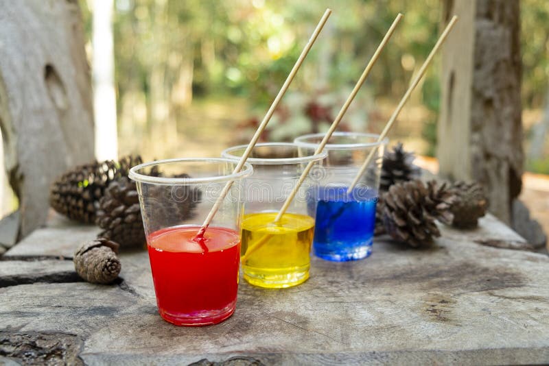 Epoxy resin blue yellow red color in cup for casting Stabilizing wood and pine cone hybrid