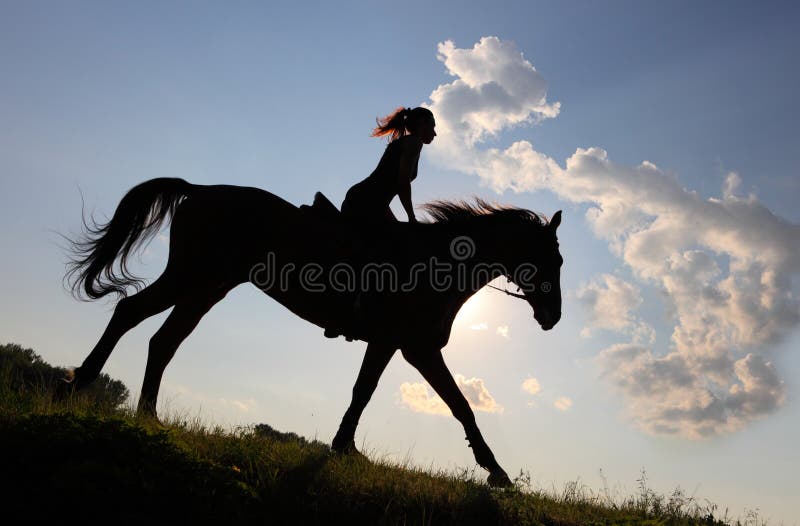 Equetsrian riding her horse at sunset