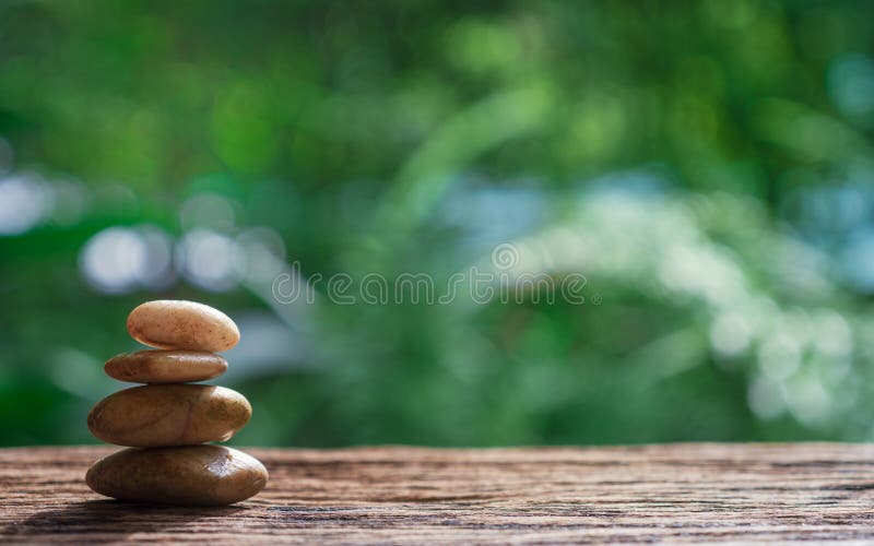 Equilibre los ZENES Stone en la madera con el fondo verde del bokeh de la naturaleza fotos de archivo libres de regalías Equilibre los ZENES Stone en la madera con el fondo verde del bokeh de la naturaleza fotos de archivo libres de regalías