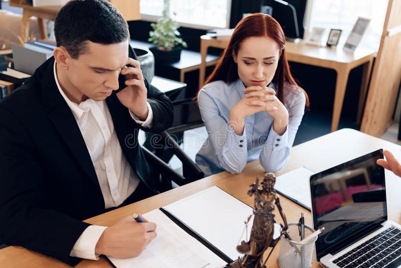 Equipaggi chi divorzia la sua moglie si consulta sul telefono con l'avvocato La donna turbata si siede accanto all'uomo che parla immagine stock libera da diritti Equipaggi chi divorzia la sua moglie si consulta sul telefono con l'avvocato La donna turbata si siede accanto all'uomo che parla immagine stock libera da diritti