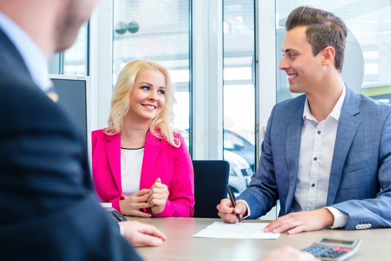 Equipaggi il contratto di vendite di firma per l'auto al concessionario auto immagini stock libere da diritti Equipaggi il contratto di vendite di firma per l'auto al concessionario auto immagini stock libere da diritti