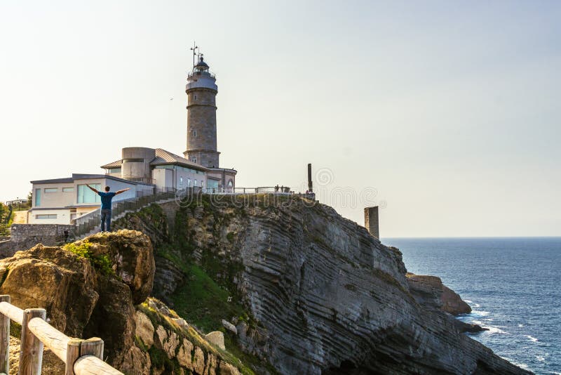 Equipaggi la posa per una foto accanto al faro a Santander, Spagna immagine stock Equipaggi la posa per una foto accanto al faro a Santander, Spagna immagine stock