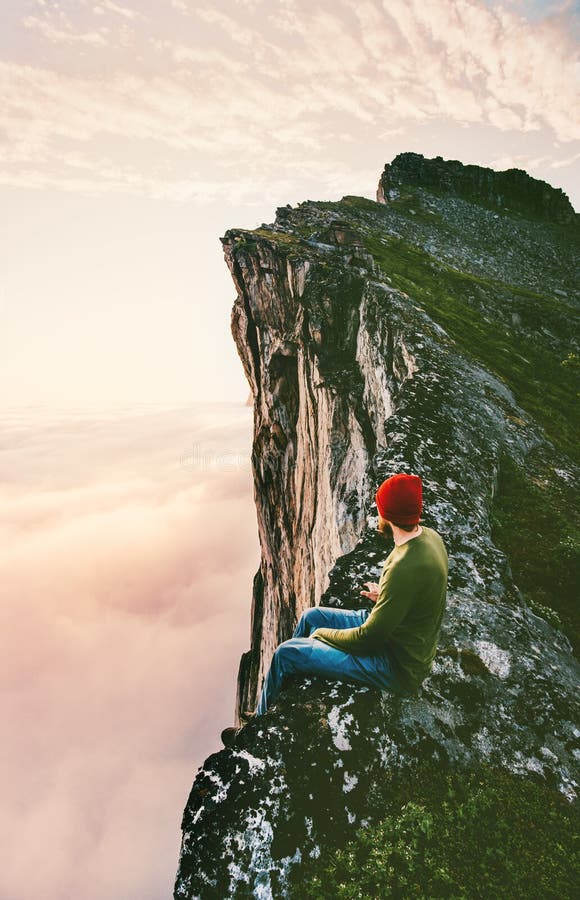 Equipaggi la seduta da solo sulla cresta della montagna del bordo sopra le nuvole fotografie stock libere da diritti Equipaggi la seduta da solo sulla cresta della montagna del bordo sopra le nuvole fotografie stock libere da diritti