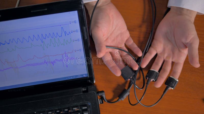 Equipe as mãos do ` s conectadas ao circuito de detector da mentira video estoque