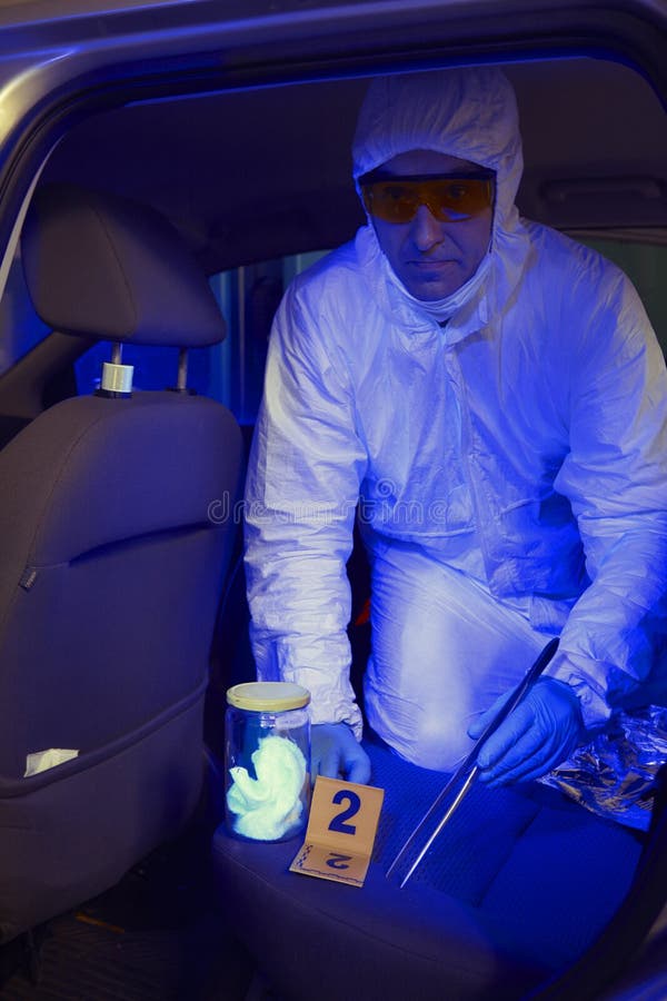 Equipe da polícia que trabalha na luz ultravioleta na coleta dos traços e das evidências imagem de stock Equipe da polícia que trabalha na luz ultravioleta na coleta dos traços e das evidências imagem de stock