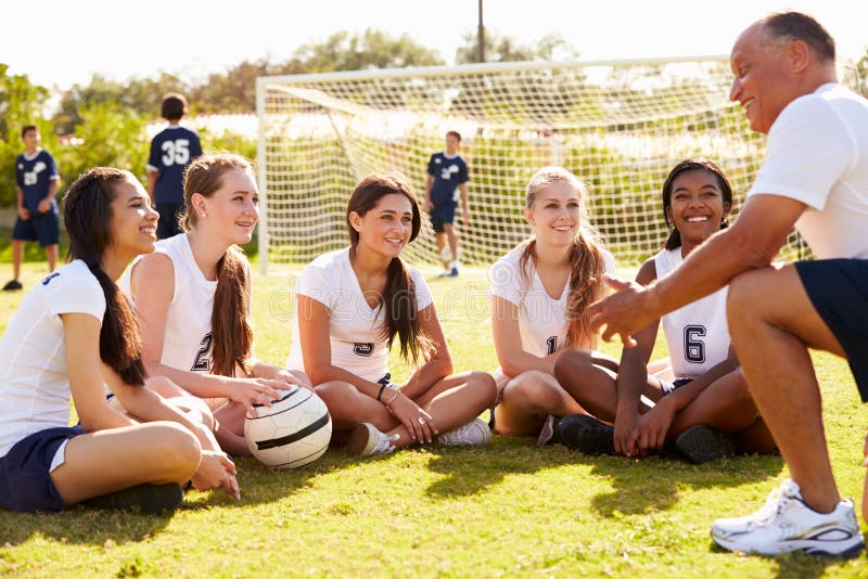 Equipe de futebol da escola de Giving Team Talk To Female High do treinador fotos de stock royalty free Equipe de futebol da escola de Giving Team Talk To Female High do treinador fotos de stock royalty free