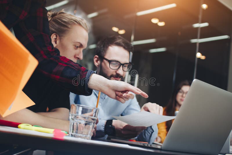 A equipe de gerentes novos trabalha em um escritório moderno em um tabl de madeira imagens de stock A equipe de gerentes novos trabalha em um escritório moderno em um tabl de madeira imagens de stock