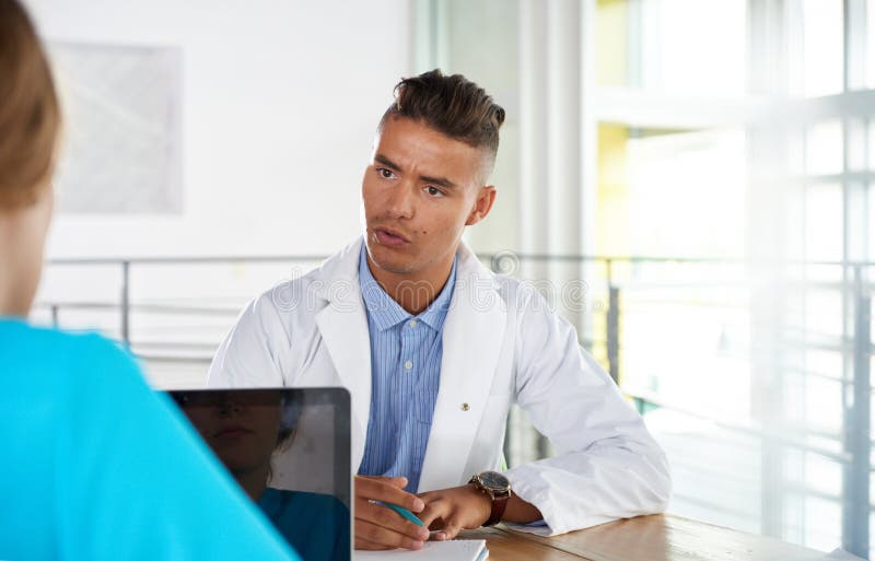 Equipe do doutor e da enfermeira que discutem um diagnóstico paciente que senta-se na mesa no escritório moderno brilhante fotos de stock Equipe do doutor e da enfermeira que discutem um diagnóstico paciente que senta-se na mesa no escritório moderno brilhante fotos de stock