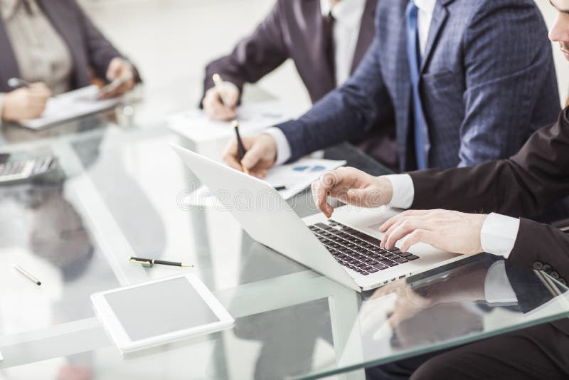 A equipe do negócio que usa um portátil está fazendo um relatório de mercado no local de trabalho foto de stock A equipe do negócio que usa um portátil está fazendo um relatório de mercado no local de trabalho foto de stock