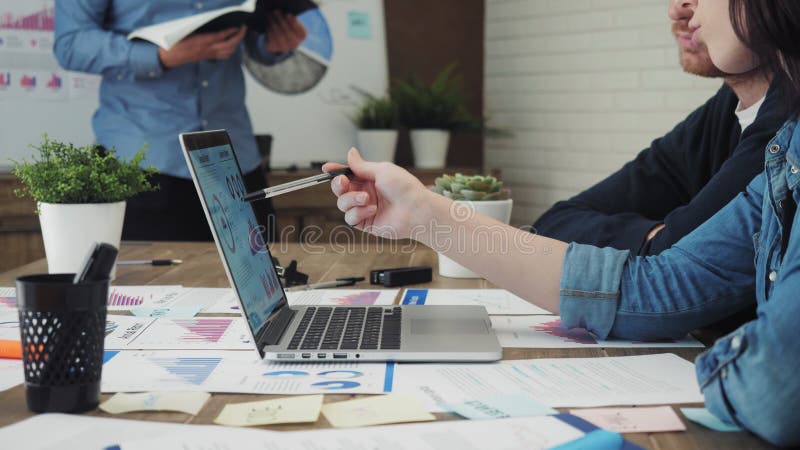 Equipe dos diretores empresariais novos que analisam dados usando o computador no escritório