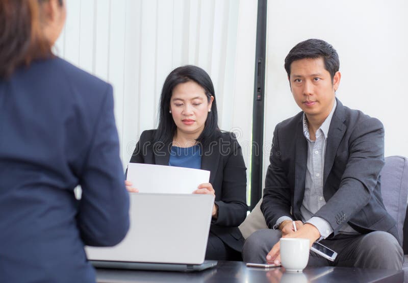 Equipe dos povos do negócio três que trabalham junto em um portátil com durante uma reunião que senta-se em torno de uma tabela imagens de stock royalty free Equipe dos povos do negócio três que trabalham junto em um portátil com durante uma reunião que senta-se em torno de uma tabela imagens de stock royalty free
