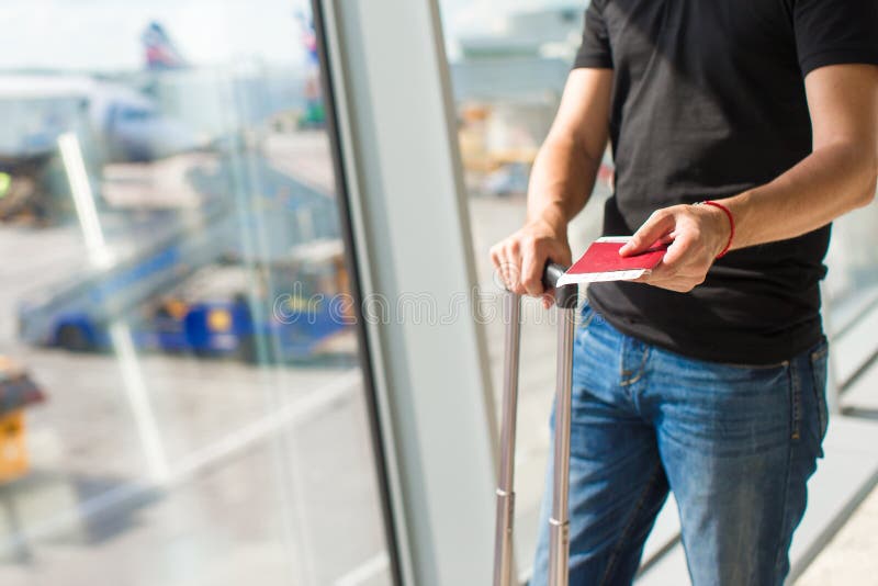 Homem a segurar passaportes e cartão de embarque no aeroporto imagem de stock royalty free