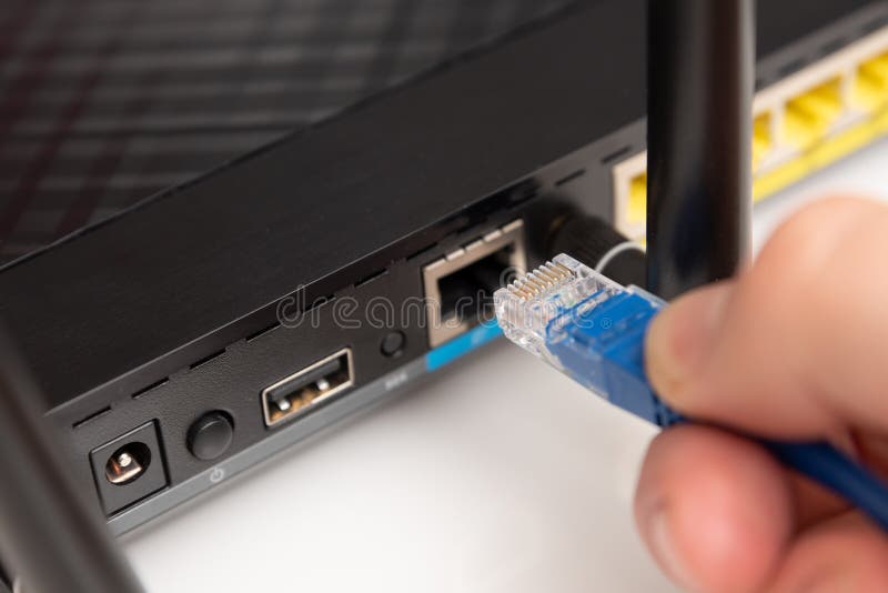 Homem liga o cabo de internet ao router imagens de stock