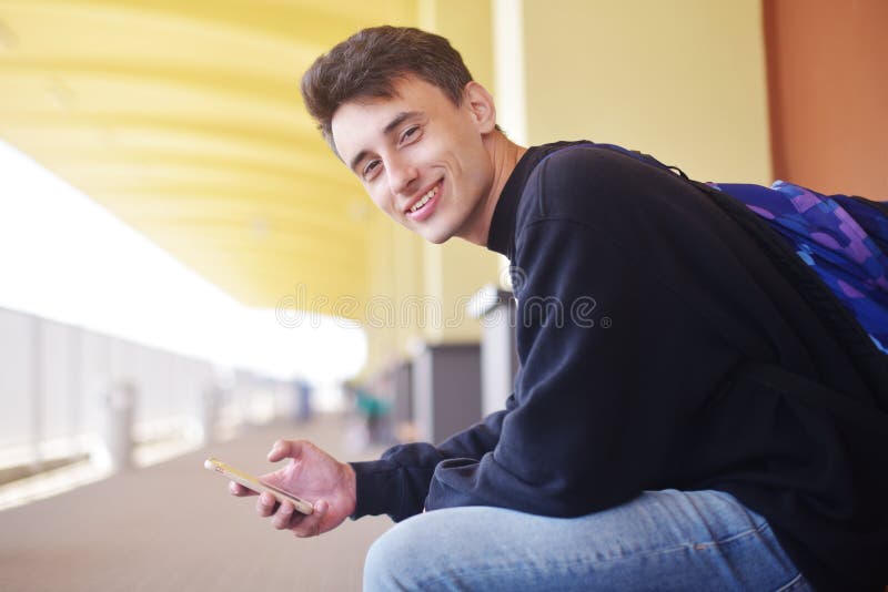 Equipe usando a aplicação móvel em seu smartphone no estação de caminhos-de-ferro, curso Considerável na estação de trem Homem au fotografia de stock royalty free Equipe usando a aplicação móvel em seu smartphone no estação de caminhos-de-ferro, curso Considerável na estação de trem Homem au fotografia de stock royalty free