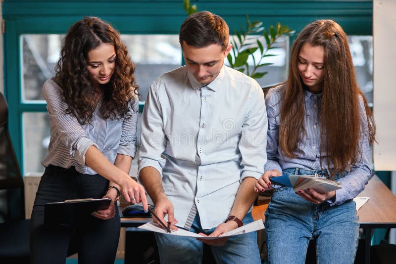 Equipo acertado de situación caucásica joven del ingeniero cerca de la tabla de madera y de hablar de nuevo proyecto Concepto del imagen de archivo libre de regalías Equipo acertado de situación caucásica joven del ingeniero cerca de la tabla de madera y de hablar de nuevo proyecto Concepto del imagen de archivo libre de regalías