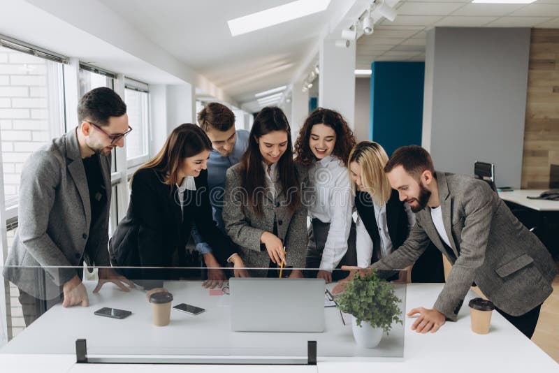 Equipo acertado Grupo de hombres de negocios jovenes que trabajan y que comunican junto en oficina creativa imagen de archivo Equipo acertado Grupo de hombres de negocios jovenes que trabajan y que comunican junto en oficina creativa imagen de archivo