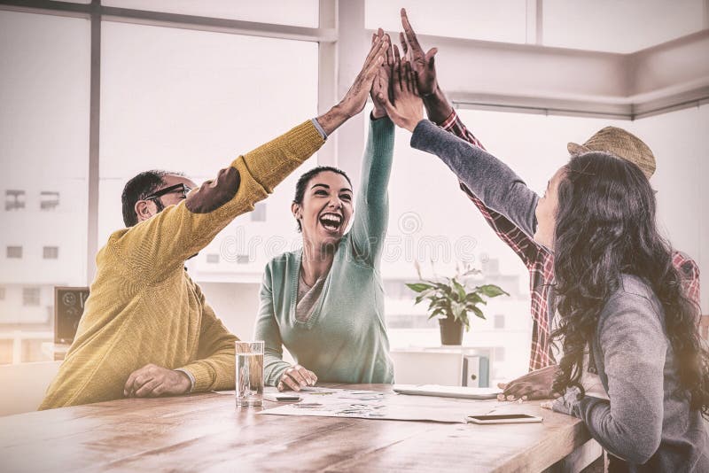 Equipo alegre del negocio que hace el alto cinco en oficina creativa foto de archivo libre de regalías Equipo alegre del negocio que hace el alto cinco en oficina creativa foto de archivo libre de regalías
