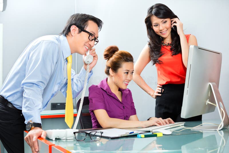 Equipo asiático de la oficina que trabaja difícilmente para un éxito empresarial fotografía de archivo Equipo asiático de la oficina que trabaja difícilmente para un éxito empresarial fotografía de archivo