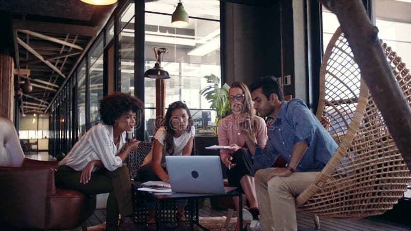 Equipo creativo del negocio usando el ordenador portátil durante la reunión metrajes
