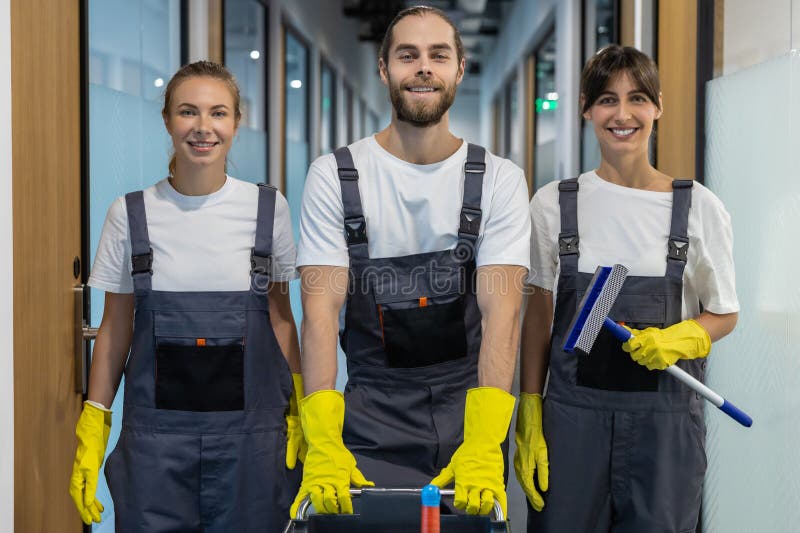 Equipo de limpieza caminando por el pasillo de la oficina con equipo de limpieza imagen de archivo libre de regalías