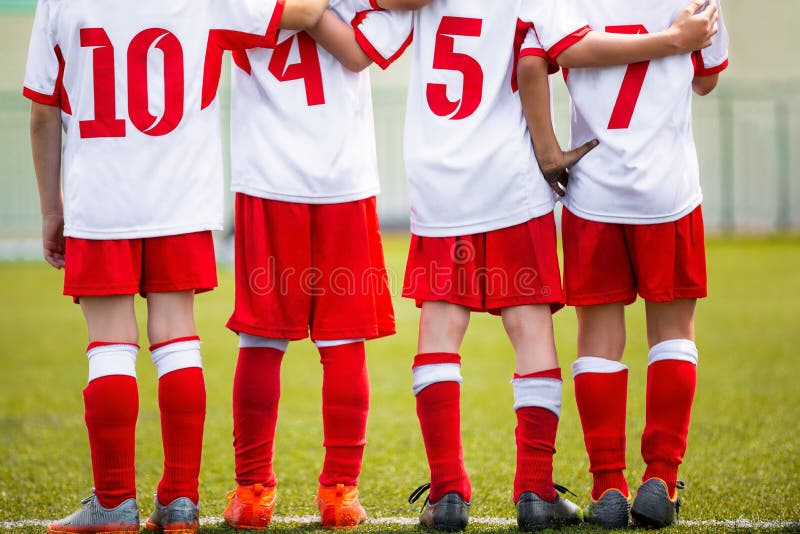 Football children team. Kids soccer substitute players standing together on a row. Football sports tournament for young boys. Four kids watching football penalties game on a pitch. Football children team. Kids soccer substitute players standing together on a row. Football sports tournament for young boys. Four kids watching football penalties game on a pitch