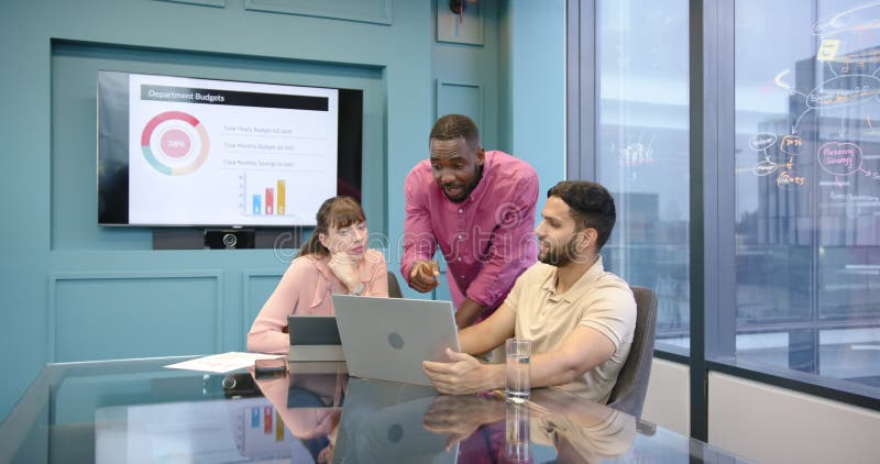 Equipo de negocios discutiendo el proyecto utilizando la pantalla de presentación y portátil en la oficina almacen de video
