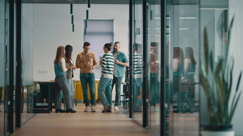 Equipo de negocios en una moderna oficina de inicio de espacio abierto caminando juntos. Diversos grupos de empresarios sonriendo metrajes
