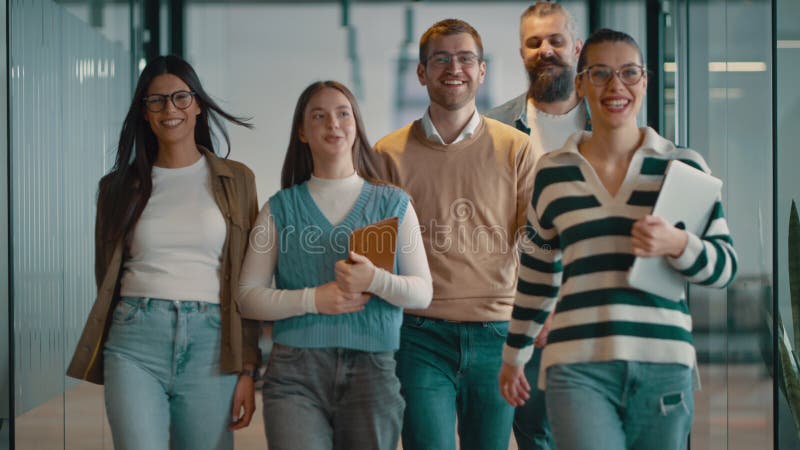 Equipo de negocios en una moderna oficina de inicio de espacio abierto caminando juntos. Diversos grupos de empresarios sonriendo almacen de video