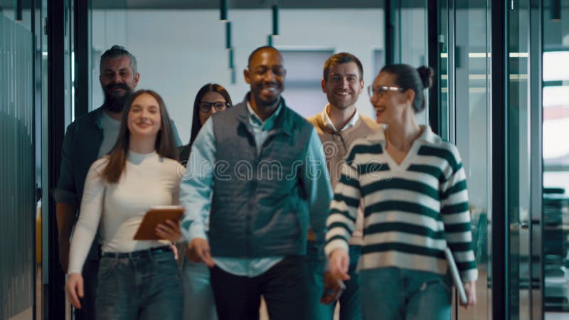 Equipo de negocios en una moderna oficina de inicio de espacio abierto caminando juntos. Diversos grupos de empresarios sonriendo almacen de video