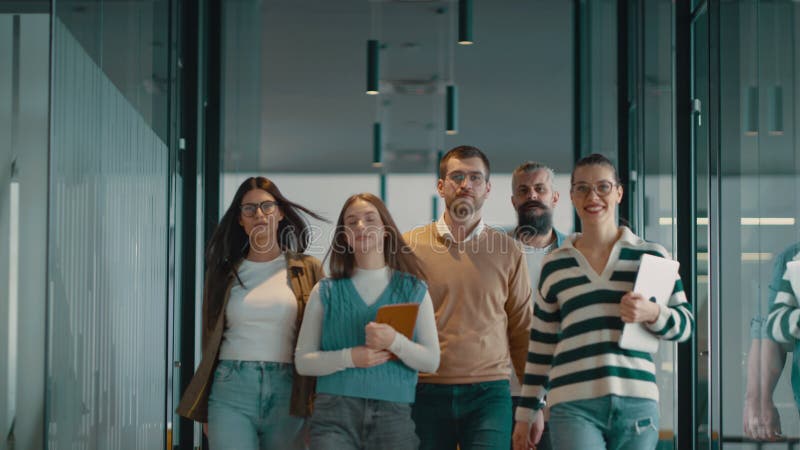 Equipo de negocios en una moderna oficina de inicio de espacio abierto caminando juntos. Diversos grupos de empresarios sonriendo almacen de video