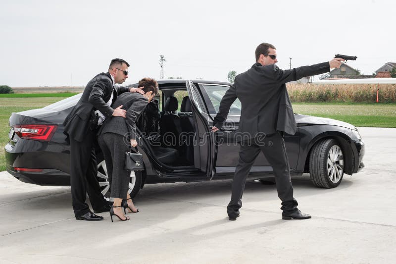 Equipo de seguridad de guardaespaldas protege vip de celebridades en limusina de coche  fotografía de archivo