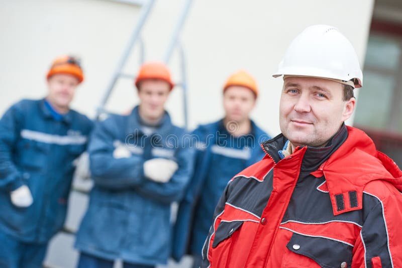 Equipo de técnicos de los trabajadores de construcción con el capataz en frente