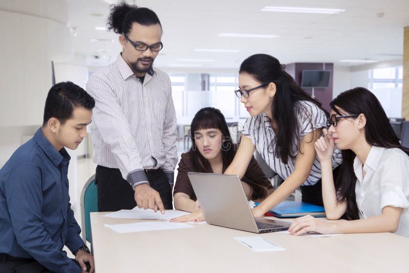 Equipo del negocio que discute informe financiero en oficina foto de archivo libre de regalías Equipo del negocio que discute informe financiero en oficina foto de archivo libre de regalías