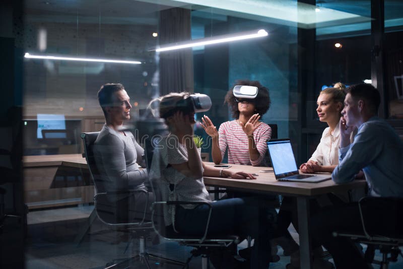 Equipo multiétnico del negocio usando las auriculares de la realidad virtual