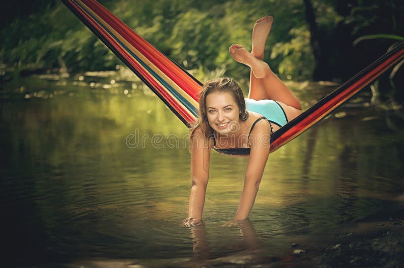 Equitação bonita da menina em uma rede sobre a água foto de stock Equitação bonita da menina em uma rede sobre a água foto de stock