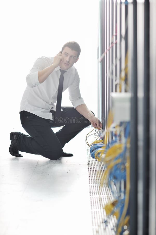 Er führt die Unterhaltung durch Telefon am Netzraum aus lizenzfreies stockbild Er führt die Unterhaltung durch Telefon am Netzraum aus lizenzfreies stockbild