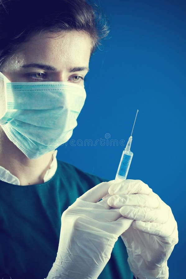 Erba medica che esamina una siringa fotografia stock libera da diritti Erba medica che esamina una siringa fotografia stock libera da diritti