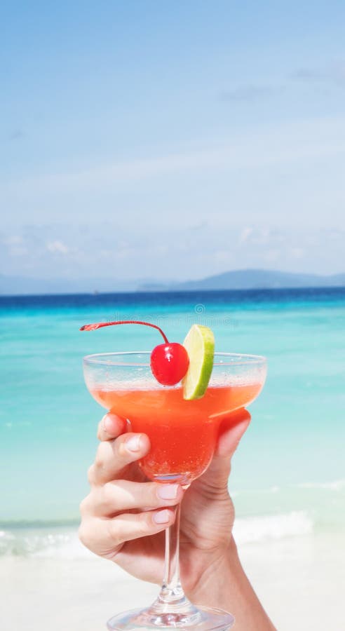 Erdbeeredaiquiricocktail in Frau ` s Hand am Strandrestaurant lizenzfreies stockbild Erdbeeredaiquiricocktail in Frau ` s Hand am Strandrestaurant lizenzfreies stockbild