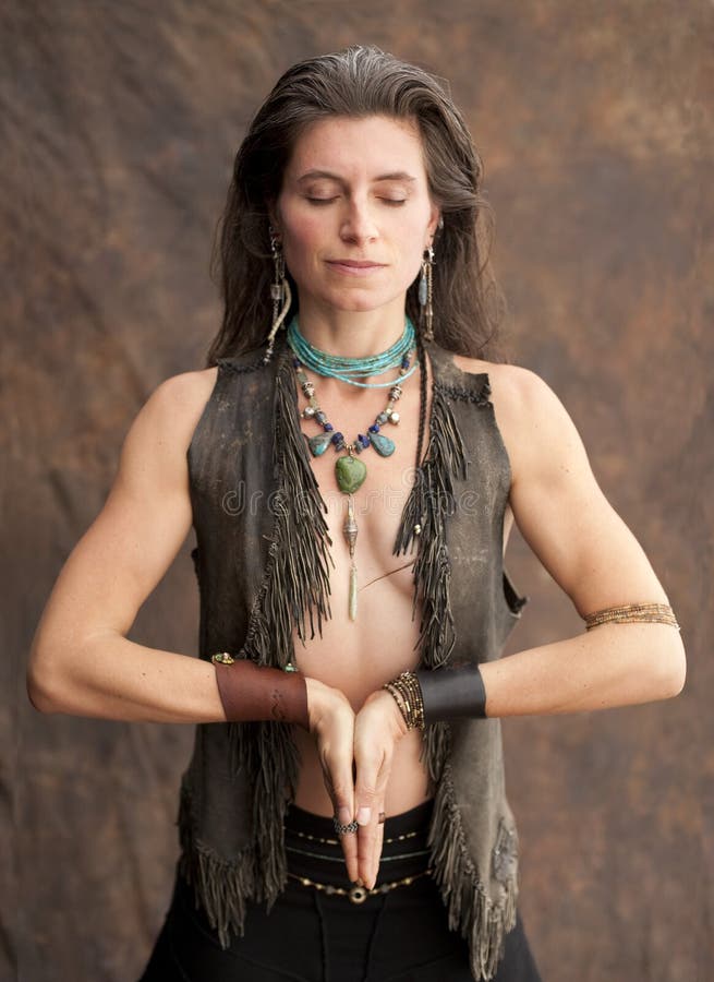 Beautiful wild spirit woman in shamnic yoga prayer. She is adorned in beautiful stones. . Beautiful wild spirit woman in shamnic yoga prayer. She is adorned in beautiful stones.