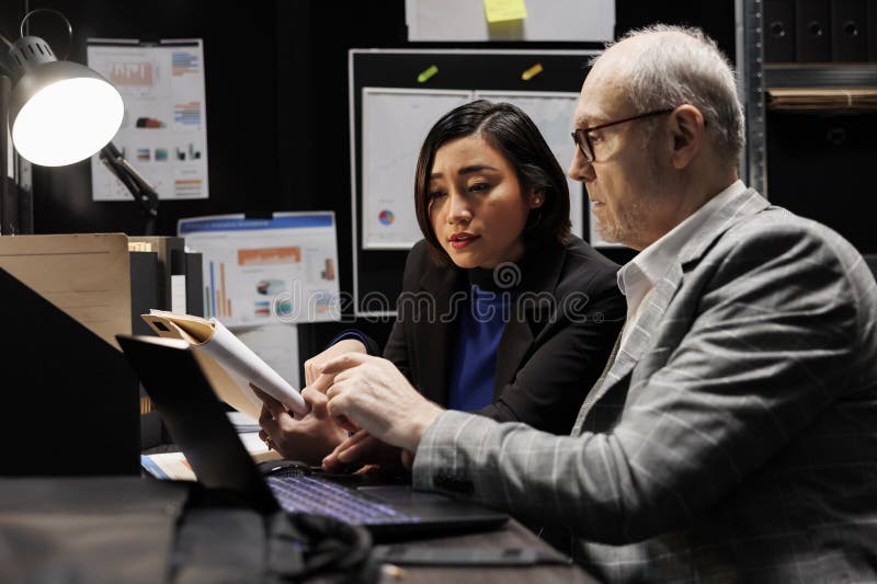 Experienced business manager and consultant employee brainstorming administrative market data analysis paperwork. Teamwork in archival depository office filled with statistic flowcharts. Experienced business manager and consultant employee brainstorming administrative market data analysis paperwork. Teamwork in archival depository office filled with statistic flowcharts