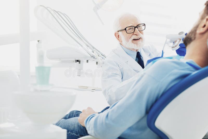 Erfaren manlig tandläkareavvänjningpatient royaltyfri bild Erfaren manlig tandläkareavvänjningpatient royaltyfri bild