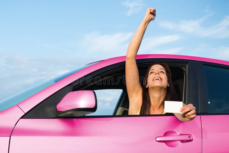 Erfolgreiche Frau, die Führerschein in ihrem Auto hält