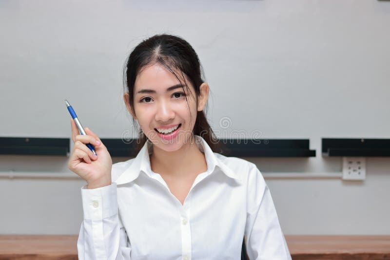 Erfolgreiche junge asiatische Geschäftsfrau mit dem Stift, der Idee an Arbeitsplatz hat stockfotografie Erfolgreiche junge asiatische Geschäftsfrau mit dem Stift, der Idee an Arbeitsplatz hat stockfotografie